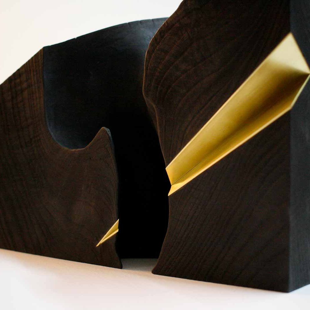 Wood sculpture with brass inlay