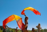 Woman dancing with orange and yellow flags