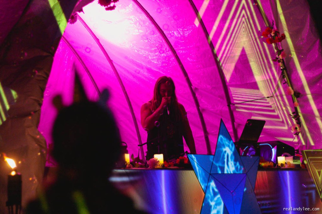 Man holding microphone on brightly coloured dome stage