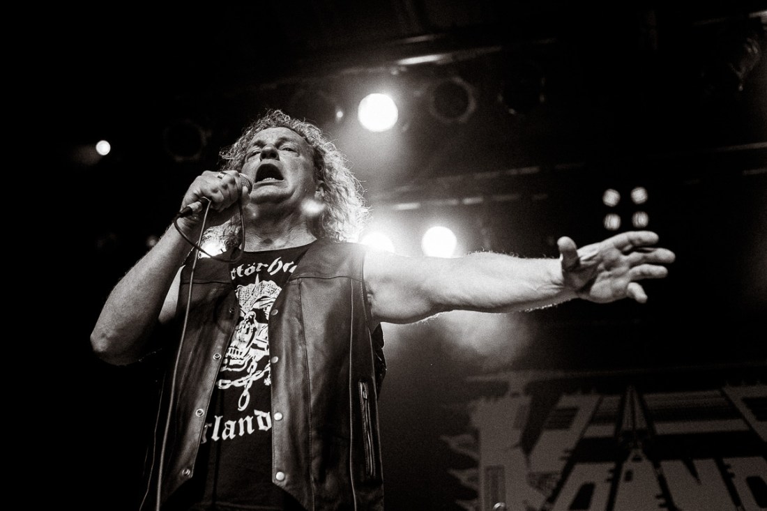 Black-and-white concert photo of heavy metal singer wearing a Motörhead shirt and leather vest.