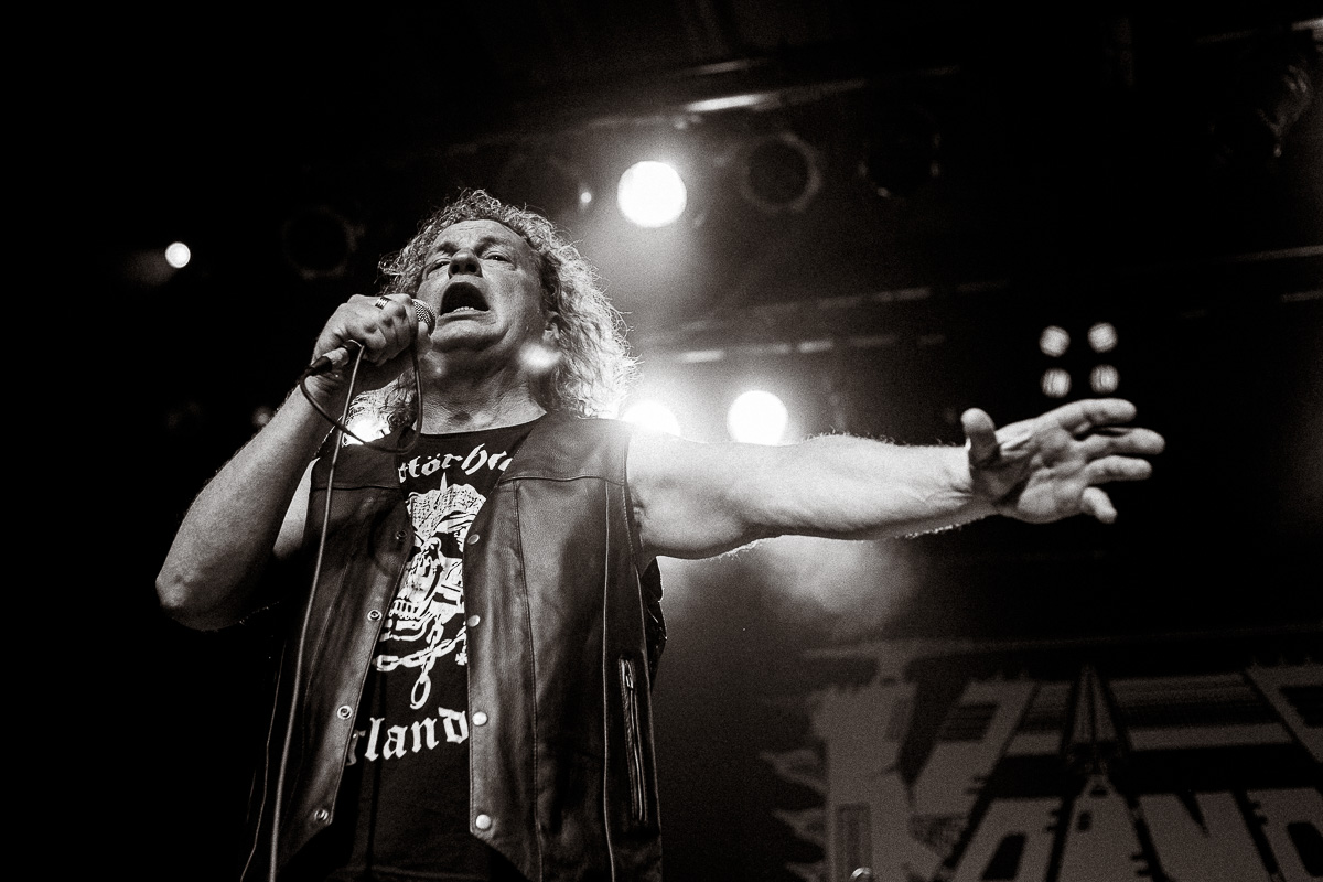 Black-and-white concert photo of heavy metal singer wearing a Motörhead shirt and leather vest.