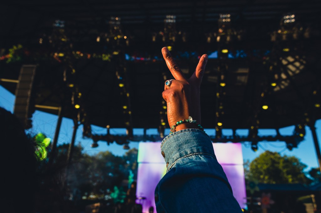 Black woman in audience holding up peace sign with ring and bracelet at Luminato Festival. © Andy Lee, 2022. realandylee.com
