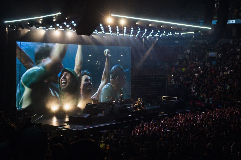 Zack de la Rocha smiles with Rage Against the Machine bandmates onstage after their second Toronto concert in July 2022. © Andy Lee, 2022. realandylee.com