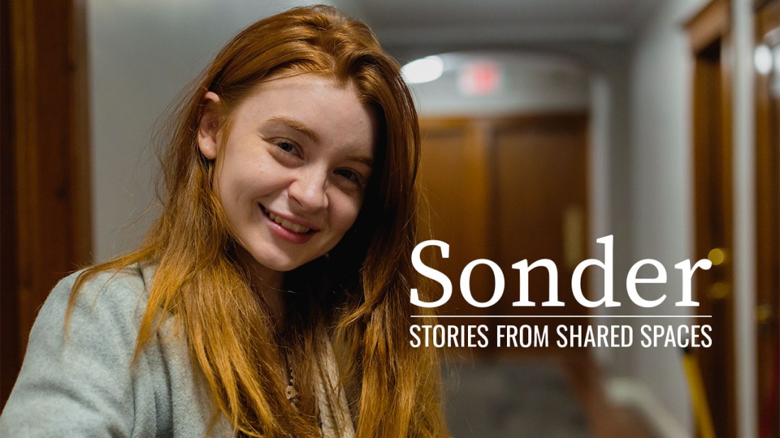 Smiling redhead woman in apartment hallway