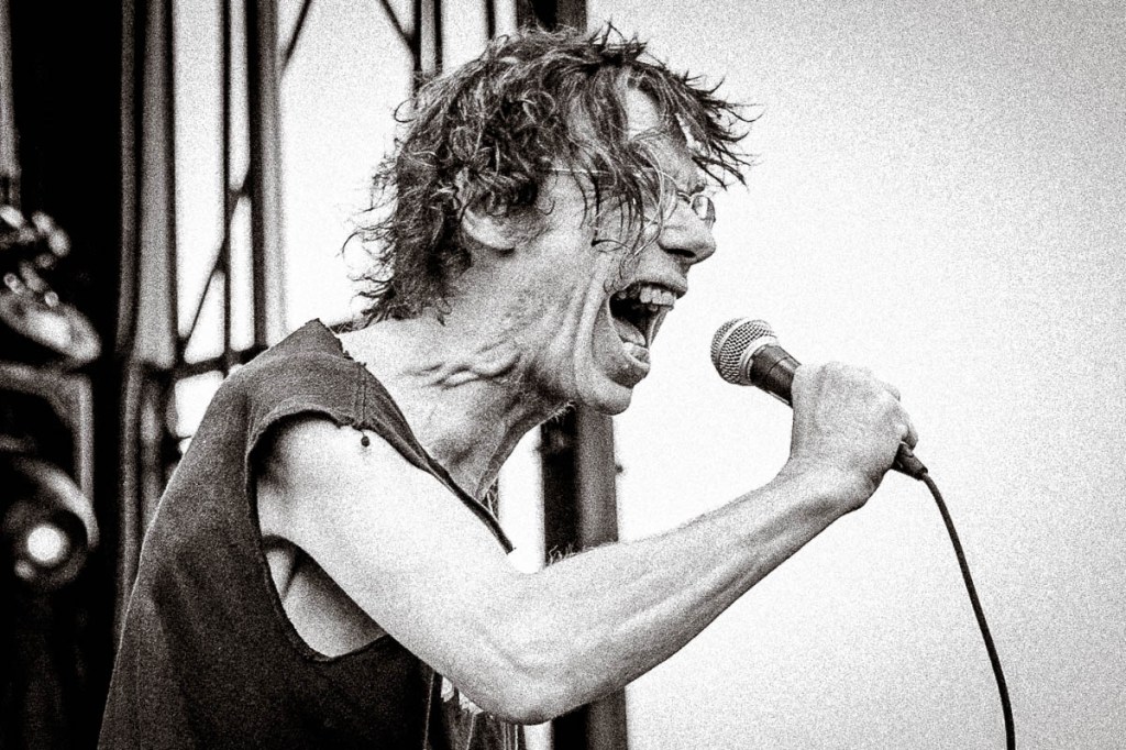 Subhumans frontman Dick Lucas shouting into a microphone