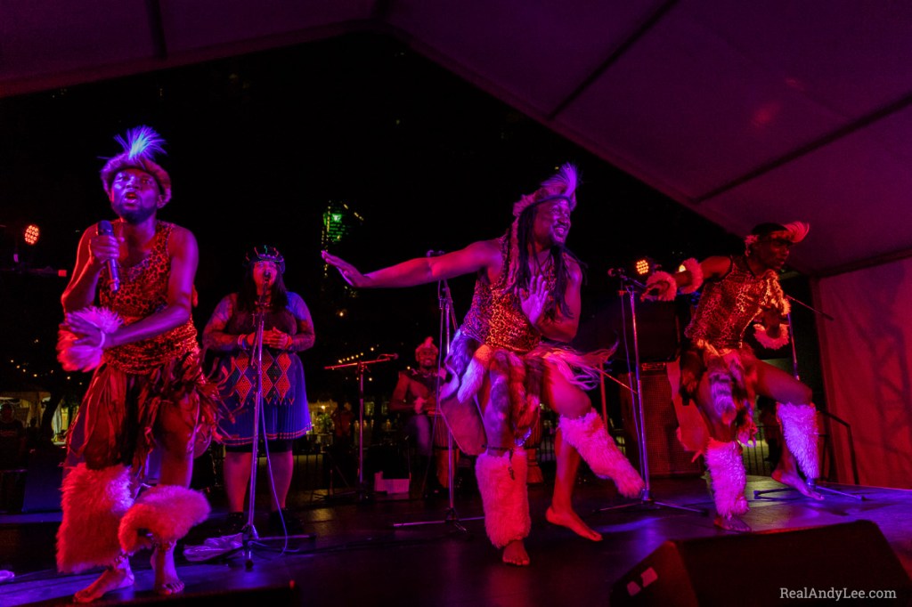 Dancers in traditional Southern African attire performing onstage at night